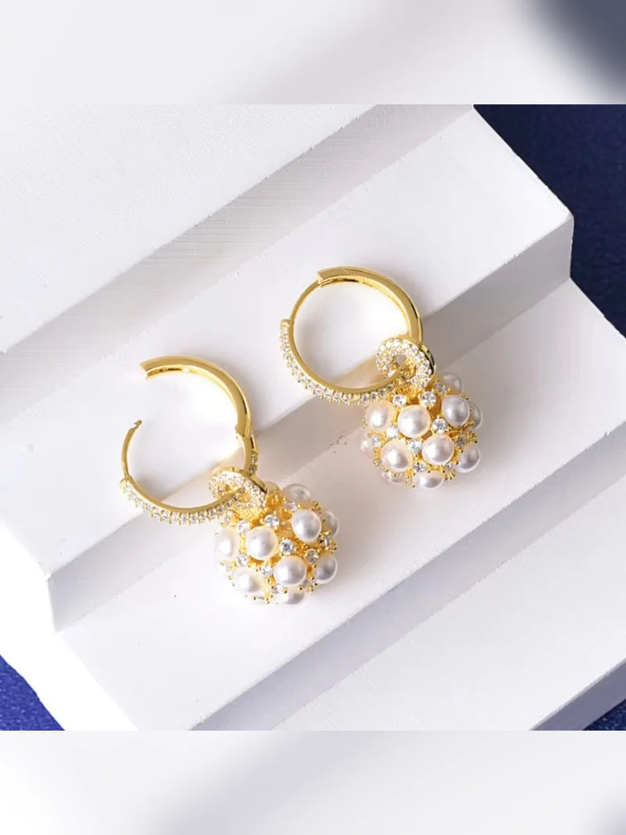 Aretes de aro con perlas sobre escalones blancos