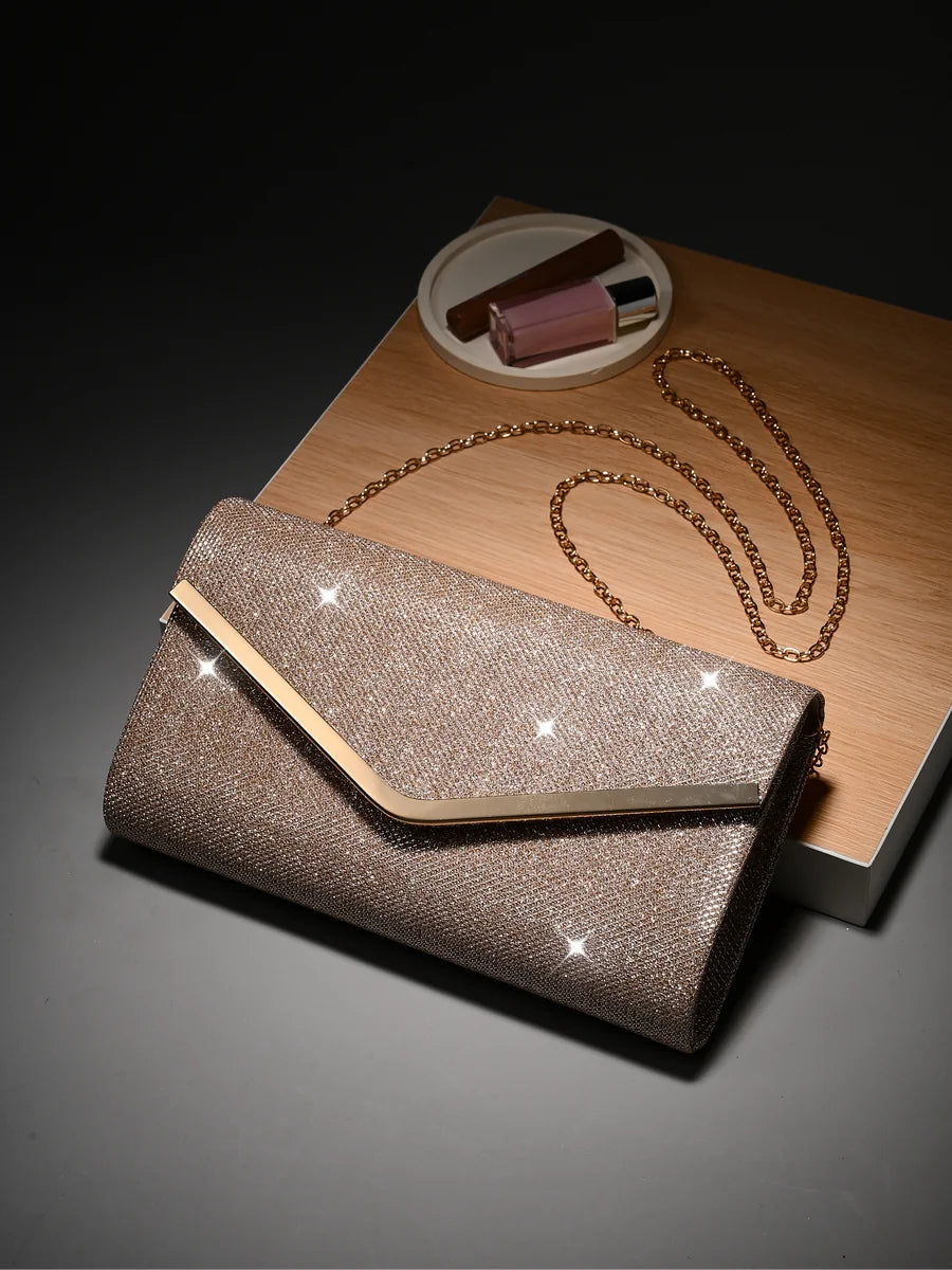 Bolso de mano brillante con cadena dorada sobre una base de madera