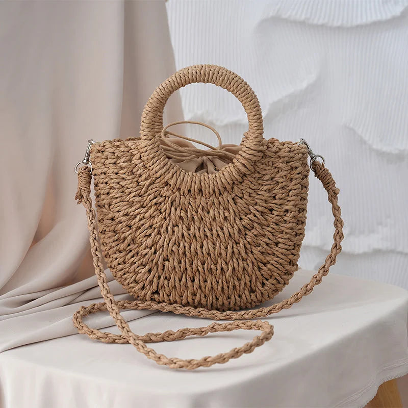 Bolso de paja tejida de media luna color caqui con asas redondas y trenza larga