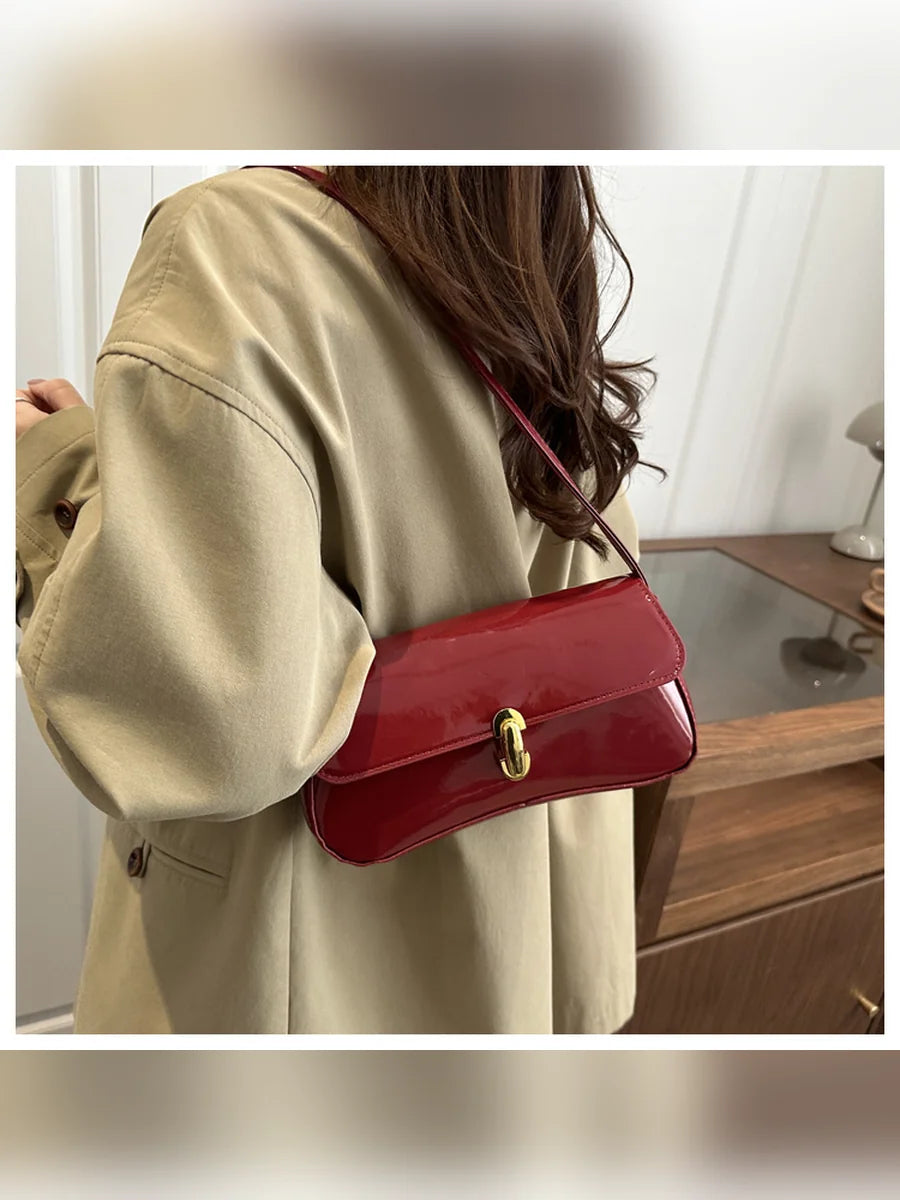 Mujer con abrigo beige llevando el bolso de hombro rojo