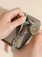 Manos abriendo el bolsillo con cremallera de la cartera compacta para sacar monedas