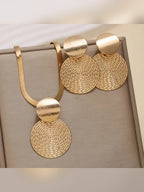 Set de collar y aretes de disco dorado con textura calada sobre fondo gris