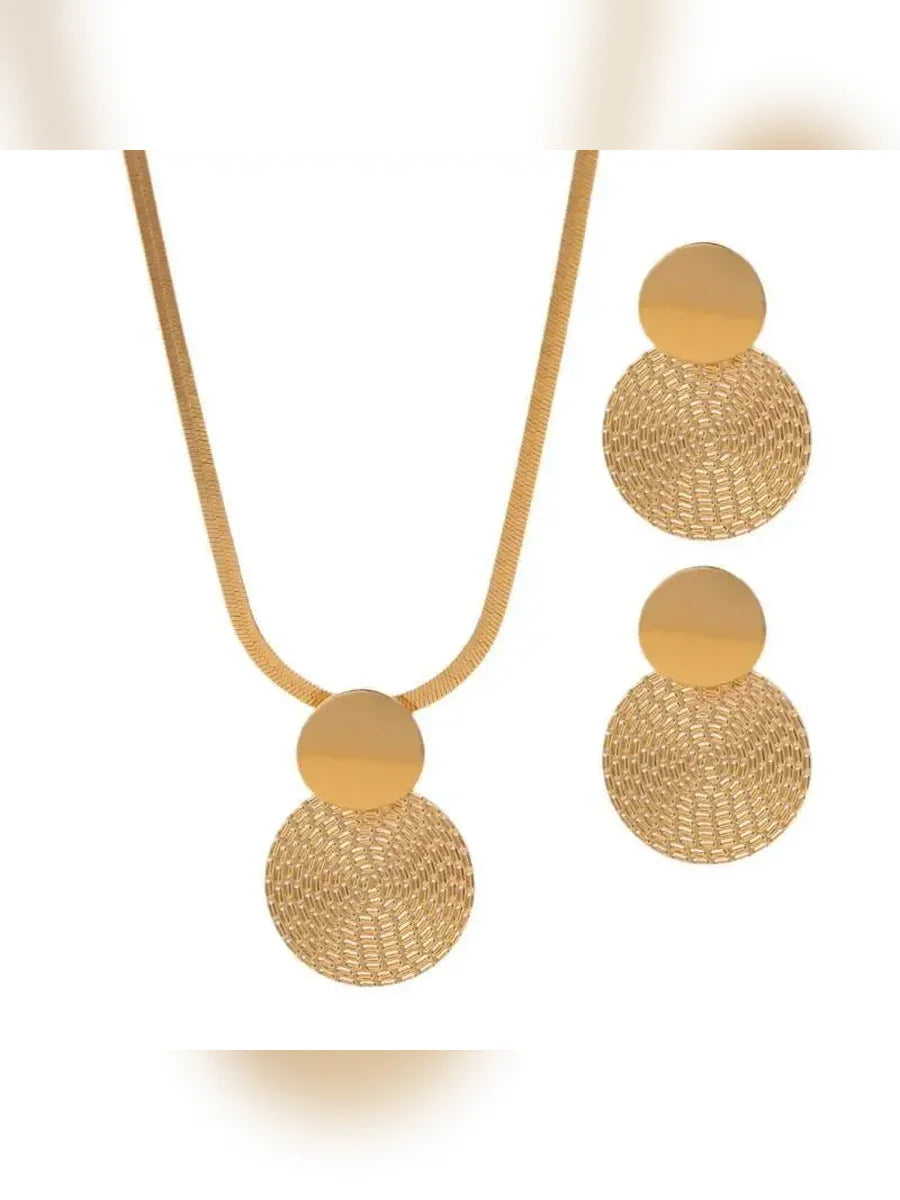 Collar y aretes de disco dorado con textura calada sobre fondo blanco