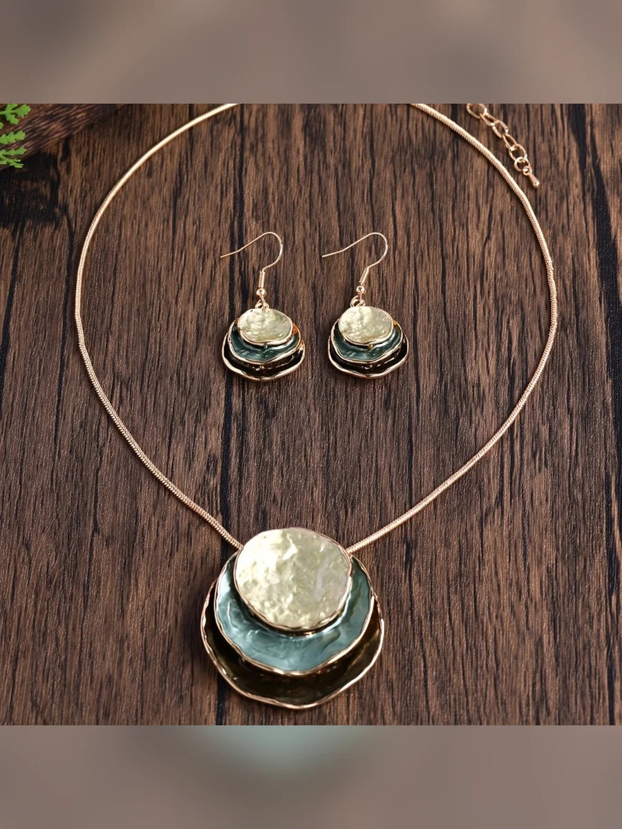 Collar largo con dije circular esmaltado y aretes colgantes a juego