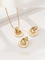 Collar dorado con dije de aros y par de aretes a juego sobre fondo claro