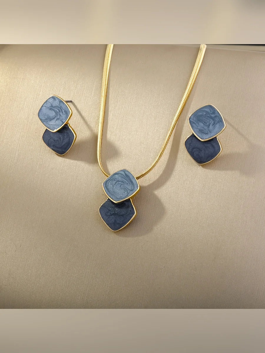 Collar de cadena plana y aretes con rombos esmaltados en azul