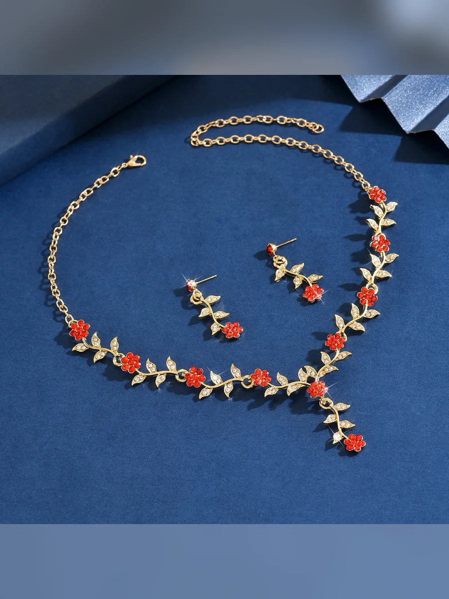Set dorado de hojas con flores rojas y cristales sobre fondo azul