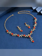Set dorado de hojas con flores rojas y cristales sobre fondo azul
