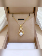 Collar dorado con dije de perla y cristales en una caja