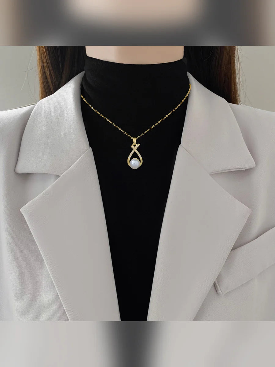 Mujer con blazer claro luciendo el collar dorado con dije de perla