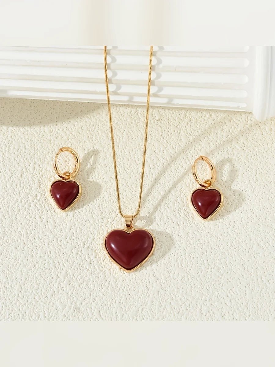 Collar largo con corazón rojo y aretes de aro con corazón colgante