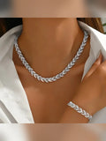 Mujer con collar y pulsera plateados trenzados con cristales sobre camisa blanca