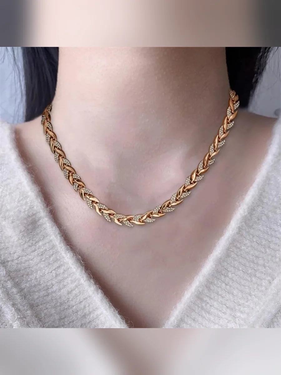 Collar y pulsera trenzados en oro rosa con camisa blanca