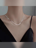 Collar plateado doble capa con top de tirantes negro