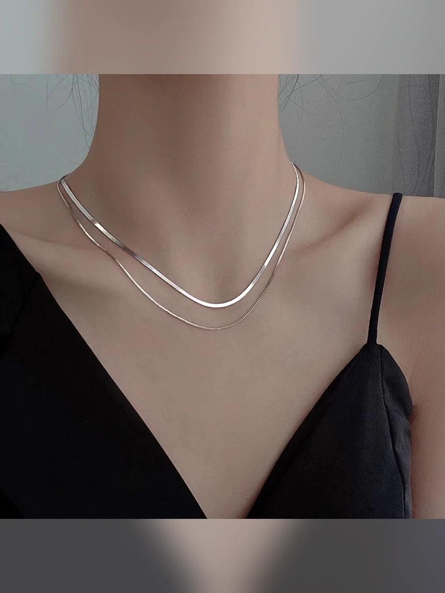 Collar plateado doble capa con top de tirantes negro