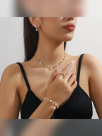 Mujer con collar corto dorado de cristales, pulsera y anillo