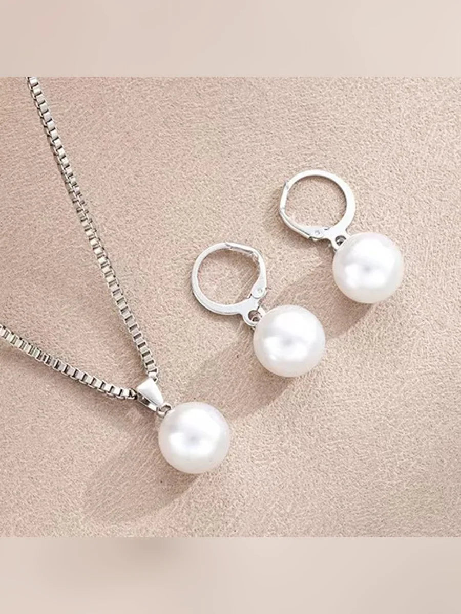 Aretes de aro plateados con perla blanca y collar plateado con dije de perla