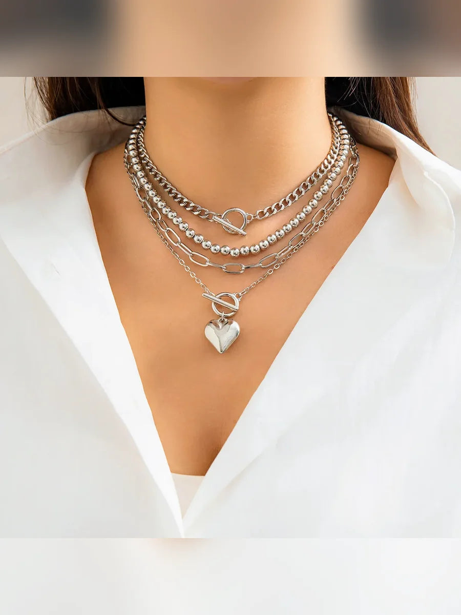 Mujer con collar multicapa plateado de cadenas y bolitas con cierre OT