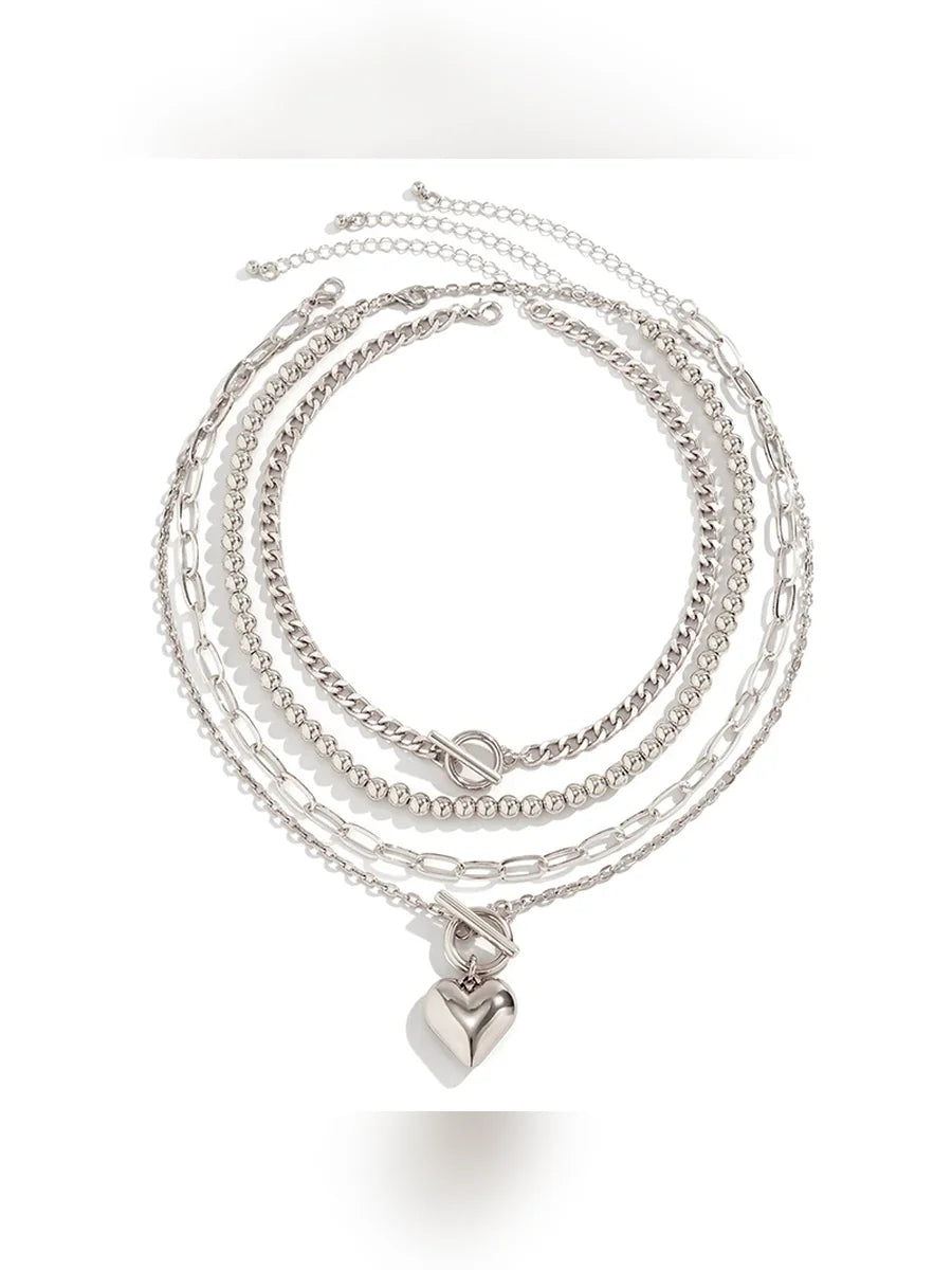 Set de collares plateados con dije de corazón sobre fondo blanco