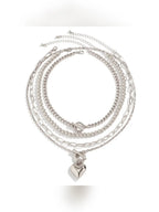 Set de collares plateados con dije de corazón sobre fondo blanco