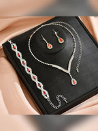 Set de collar, aretes y pulsera con cristales rojos en caja negra