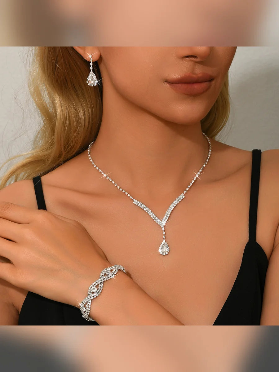 Mujer con collar en V de cristales y pulsera trenzada con aretes de gota