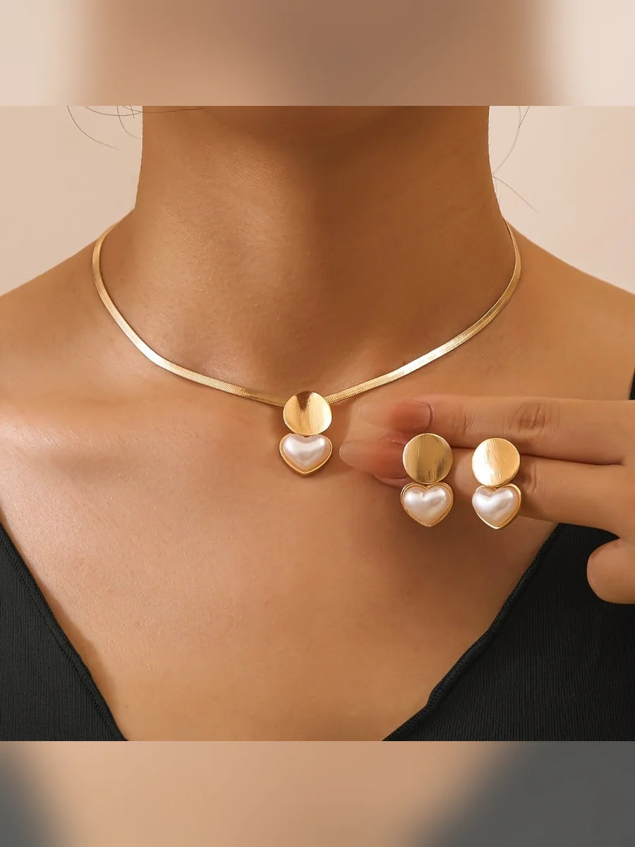 Mujer luciendo el collar de cadena plana dorada con dije de corazón nacarado