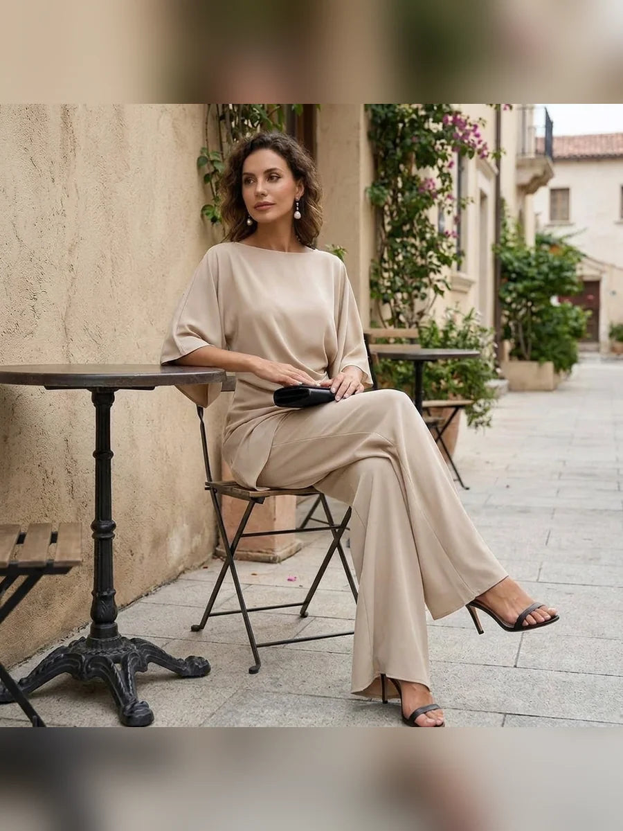 Mujer sentada en una terraza con conjunto de blusa y pantalón ancho en color beige